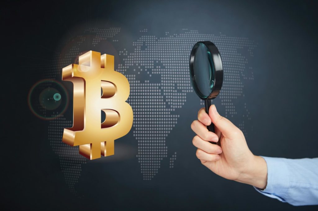 Golden Bitcoin image in 3d with man scrutinizing with a magnifying glass. Stylized digital world map in the background